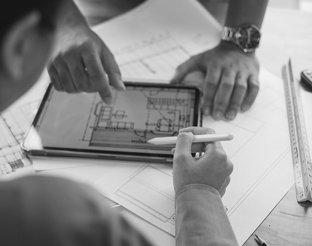 Helles schwarz-weiß Foto einer Baubesprechung mit Tablet