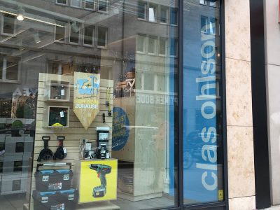 Schaufensterdes Clas Ohlson Stores in Hamburg am Jungfernstieg, Erdgeschoss, helblauees Poster mit Logo, Bohrmaschine und andere Werkzeuge