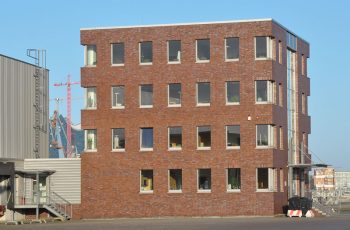 Logistic Terminal in Hamburg-Steinwerder, rotes Bürohaus und helle lange Abfertigungshalle für LKW