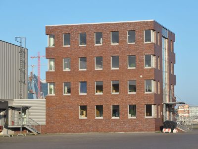 Logistic Terminal in Hamburg-Steinwerder, rotes Bürohaus und helle lange Abfertigungshalle für LKW