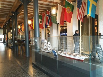 Internationales Maritimes Museum in Hamburg, Ausstellungsfläche innen mit Schiffen in Glasvitrinen und Flaggen aller Läander an der Decke
